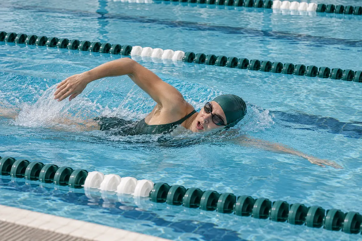 Una nadadora entrena crol en una piscina con calles